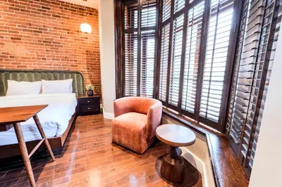 a bedroom with a bed and a chair and a table at Self Check-In Boutique Hotel - Quartier latin - Room 101 in Montréal