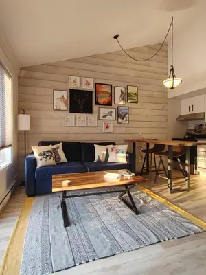 a living room with a blue couch and a table at Chalet Aventure Orford in Orford