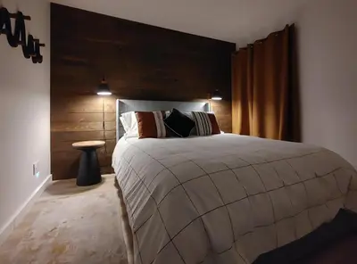 a bedroom with a large bed with a wooden headboard at Chalet Aventure Orford in Orford