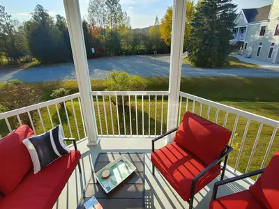 a screened in porch with two chairs and a table at Chalet Aventure Orford in Orford