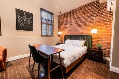 a bedroom with a brick wall and a bed and a table at Self Check-In Boutique Hotel - Quartier latin - Room 102 in Montréal