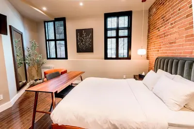 a bedroom with a brick wall and a bed and a desk at Self Check-In Boutique Hotel - Quartier latin - Room 102 in Montréal