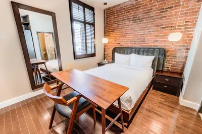 a bedroom with a bed and a table and a brick wall at Self Check-In Boutique Hotel - Quartier latin - Room 202 in Montréal
