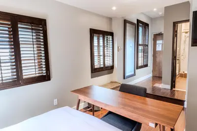 a dining room with a wooden table and some windows at Self Check-In Boutique Hotel - Quartier latin - Room 203 in Montréal