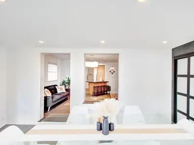 a living room with white walls and white chairs at Amazing 4-Bedrooms in Homa Montreal 20 in Montréal