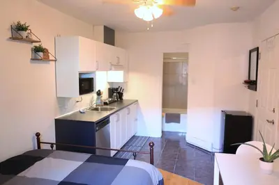 a kitchen with white cabinets and a sink at Cozy studio in montreal in Montréal
