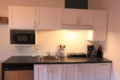 a kitchen with white cabinets and a sink at Cozy studio in montreal in Montréal
