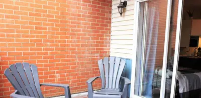 two chairs sitting in front of a brick wall at Cozy studio in montreal in Montréal