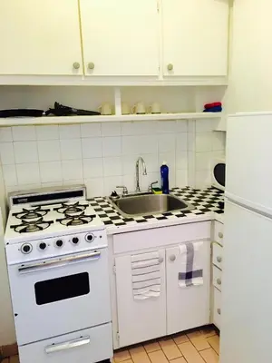 a kitchen with a white stove and a sink at Stylish Montreal Apartment Comfortable Stay in the Golden Square Mile in Montréal