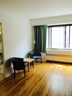 a living room with a table and a chair at Stylish Montreal Apartment Comfortable Stay in the Golden Square Mile in Montréal