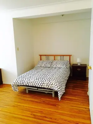 a bedroom with a bed and a wooden floor at Stylish Montreal Apartment Comfortable Stay in the Golden Square Mile in Montréal