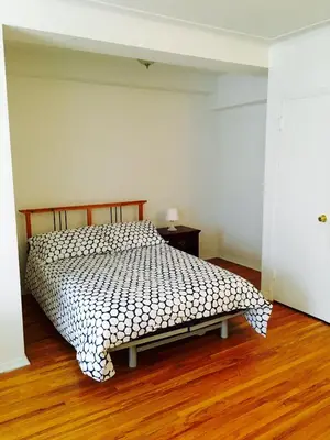 a bedroom with a bed and a wooden floor at Stylish Montreal Apartment Comfortable Stay in the Golden Square Mile in Montréal