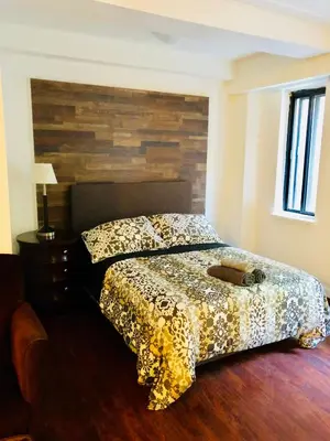 a bedroom with a bed with a wooden headboard at Stylish Montreal Apartment Comfortable Stay in the Golden Square Mile in Montréal