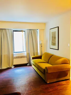 a living room with a couch and a window at Stylish Montreal Apartment Comfortable Stay in the Golden Square Mile in Montréal