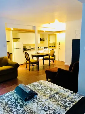 a room with a kitchen and a living room with a table at Stylish Montreal Apartment Comfortable Stay in the Golden Square Mile in Montréal