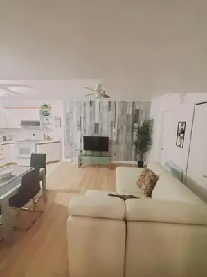 a living room with a white couch and a piano at Le cosy for familys, home work in Longueuil