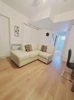 a living room with a white couch and a wooden floor at Le cosy for familys, home work in Longueuil