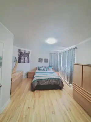 a bedroom with a bed and a large window at Le cosy for familys, home work in Longueuil