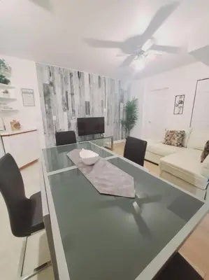 a glass table with chairs and a living room at Le cosy for familys, home work in Longueuil