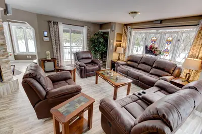 a living room with leather couches and chairs at L'Ile Enchantée in Trois-Rivières