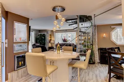 a dining room and living room with a table and chairs at L'Ile Enchantée in Trois-Rivières