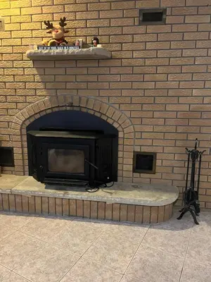 a fireplace in a brick wall with a black fire place at Zen Space in perfect location! in Montréal