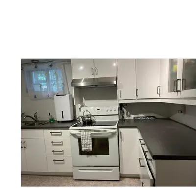 a kitchen with white cabinets and a stove top oven at Zen Space in perfect location! in Montréal