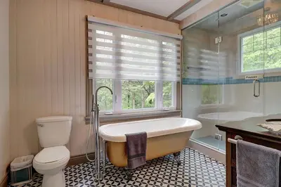 a bathroom with a tub and a toilet and a window at View and access to Lake Orford - Spa - Australe in Austin