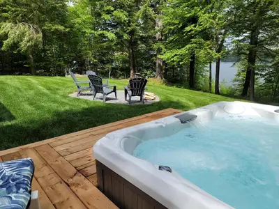 a hot tub on a wooden deck in a yard at View and access to Lake Orford - Spa - Australe in Austin