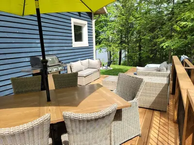 a wooden table and chairs with an umbrella on a deck at View and access to Lake Orford - Spa - Australe in Austin