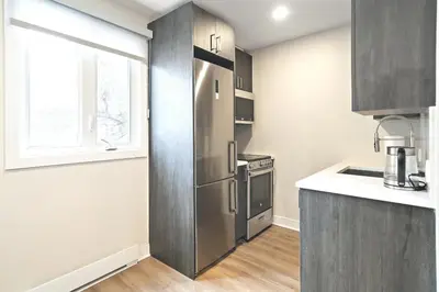 a kitchen with a stainless steel refrigerator and a window at Fancy 3 BDR in Heart of Plateau B in Montréal