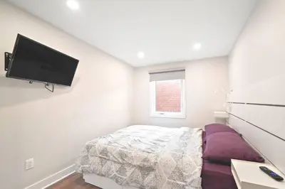 a bedroom with a bed and a flat screen tv at Fancy 3 BDR in Heart of Plateau B in Montréal