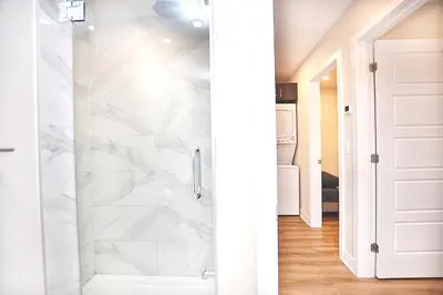 a bathroom with a shower with white marble tiles at Elegant 3BDR in Heart Of Plateau 8B in Montréal