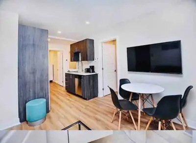a living room with a table and chairs and a kitchen at Elegant 3BDR in Heart Of Plateau 8B in Montréal