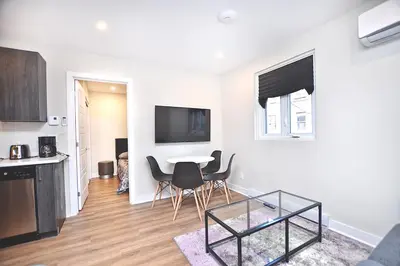 a white living room with a table and chairs at Elegant 3BDR in Heart Of Plateau 8B in Montréal