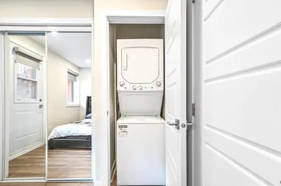 a washer and dryer in a room next to a door at Elegant 1BDR in Heart Of Plateau B in Montréal