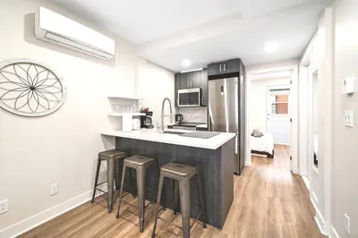 a kitchen with a counter and stools in it at Elegant 1BDR in Heart Of Plateau B in Montréal