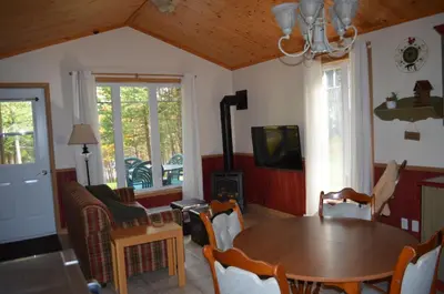 a living room with a table and a tv at Chalet Esmeralda in Piopolis