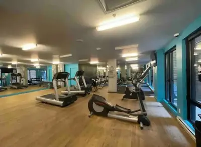 a gym with several treadmills and elliptical machines at Panoramic Apartment in the old port in Montréal