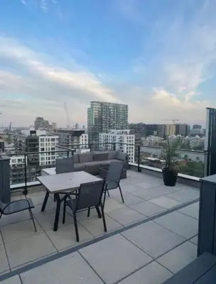 a patio with a table and chairs on a roof at Panoramic Apartment in the old port in Montréal