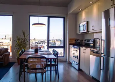 a kitchen with a table and chairs and a kitchen with a view at Panoramic Apartment in the old port in Montréal