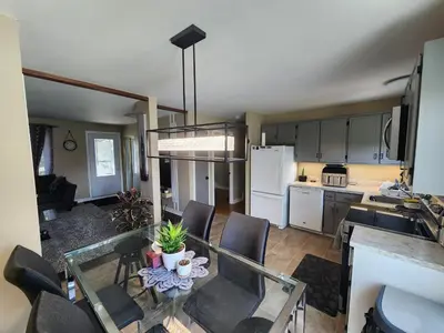 a kitchen and dining room with a table and chairs at Cozy 3-Bedroom Haven, Private Pool & Parking ! in Longueuil