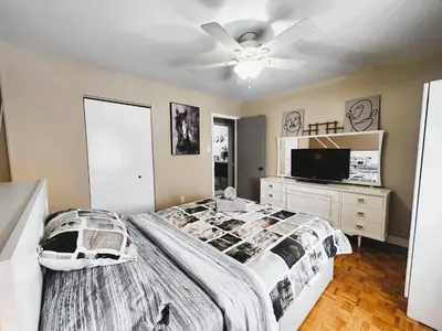 a bedroom with a bed and a flat screen tv at Cozy 3-Bedroom Haven, Private Pool & Parking ! in Longueuil