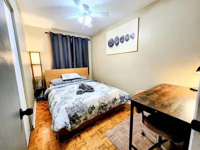 a bedroom with two beds and a desk and a ceiling fan at Cozy 3-Bedroom Haven, Private Pool & Parking ! in Longueuil