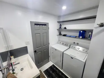 a small kitchen with a white washer and dryer at Cozy 3-Bedroom Haven, Private Pool & Parking ! in Longueuil