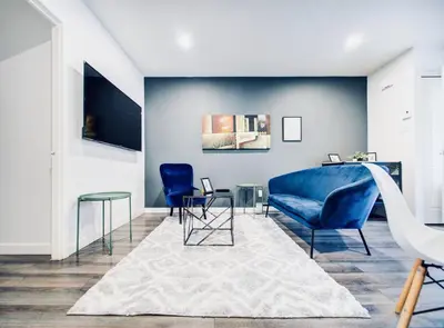 a living room with a blue couch and chairs at Charming 2 BD condo griffintown in Montréal