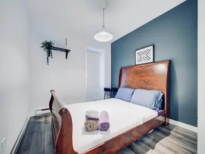 a bedroom with a bed with a wooden head board at Charming 2 BD condo griffintown in Montréal