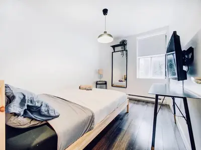 a bedroom with a bed and a desk and a television at Charming 2 BD condo griffintown in Montréal