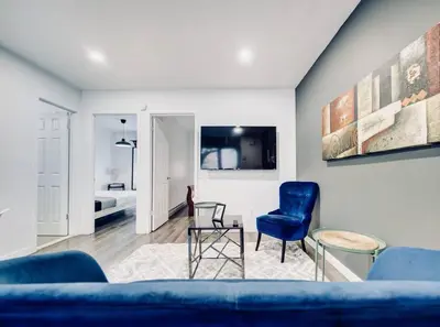 a living room with a blue couch and a chair at Charming 2 BD condo griffintown in Montréal