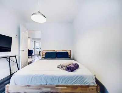 a bedroom with a large bed with blue pillows at Charming 2 BD condo griffintown in Montréal